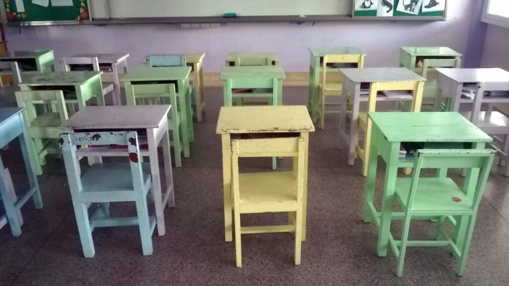 an empty classroom with colored desks