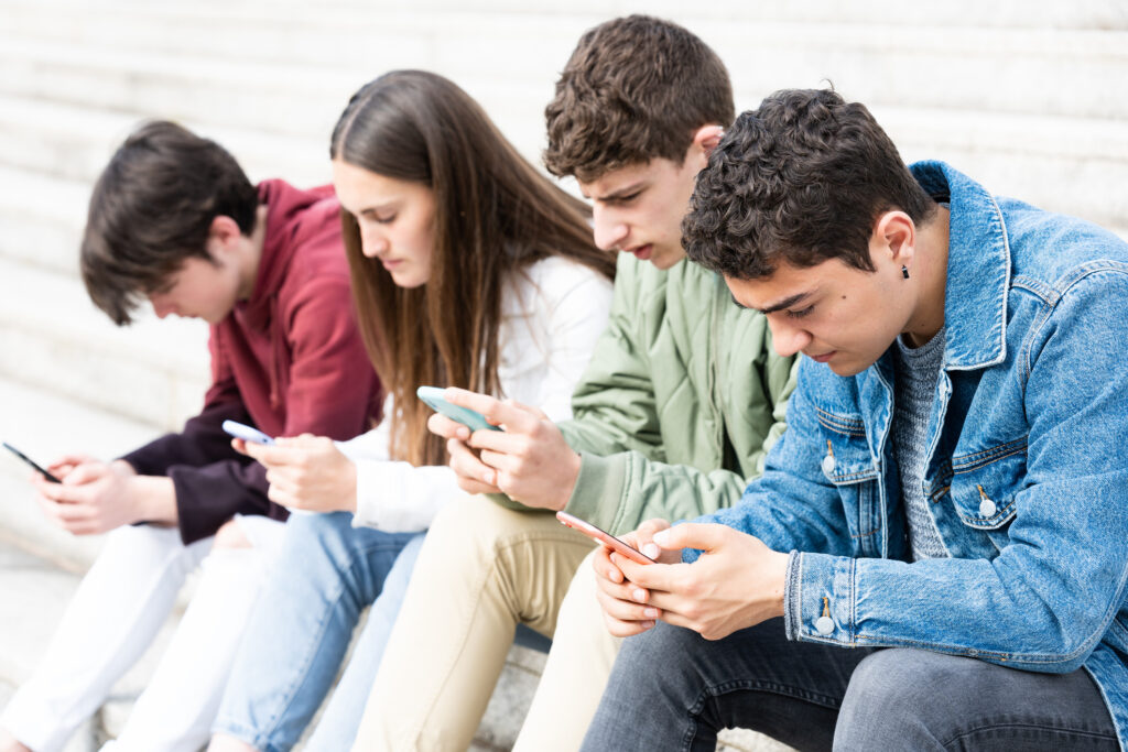 Teenagers using phone with friends