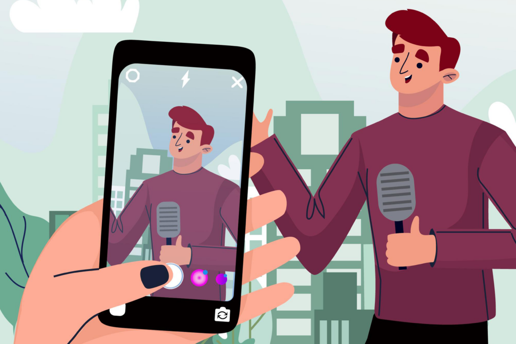 Man talking on a mic while being recorded on a smartphone by another person.