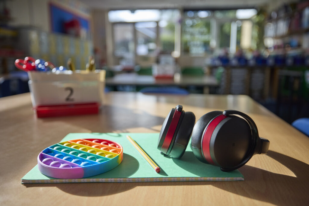Headphones and a toy to manage anxiety in a classroom