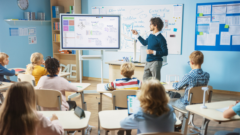Elementary school science classroom using technology to teach students.